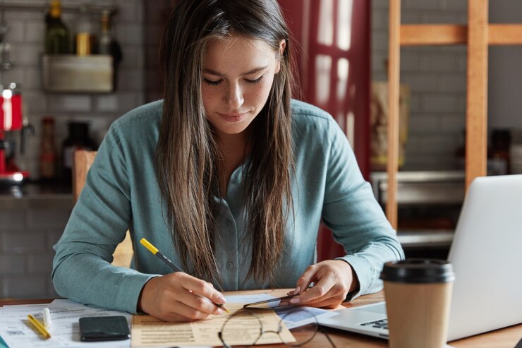 mulher branca tomando notas em caderno